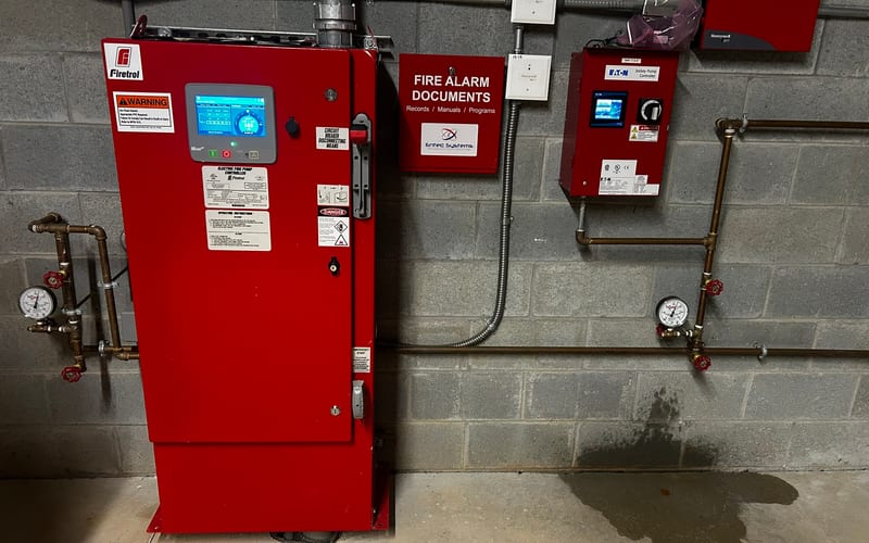 Firetrol controller installed alongside fire alarm documentation